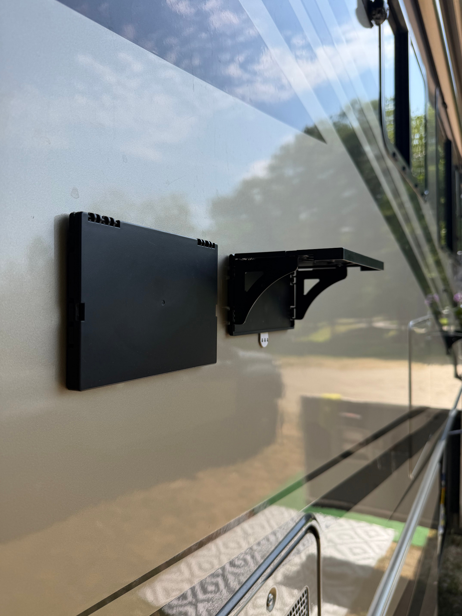 Two Pocket Shelves mounted side by side on an RV, one folded and one open